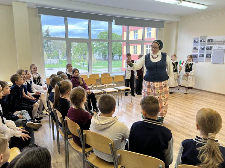 vaikai ir mokytoja tautiniais rūbais